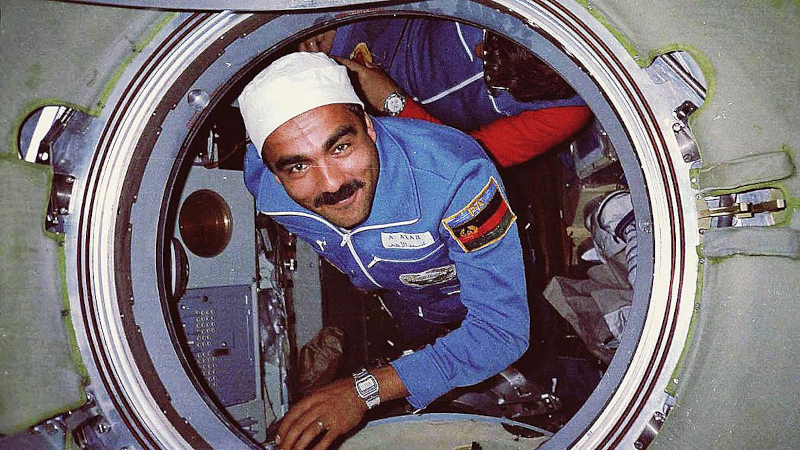 Mohmand is seen smiling as he floats through an accessway on the Mir space station