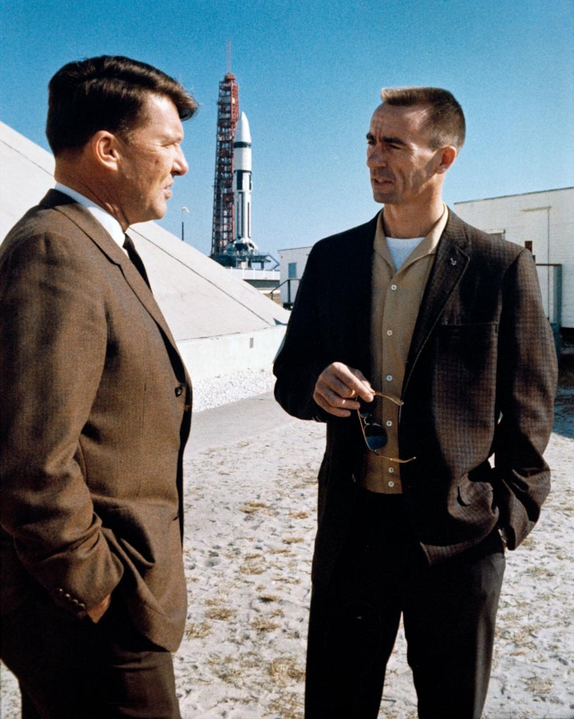 Wally Schirra and Walt Cunningham are seen in discussion near the launch pads at KSC