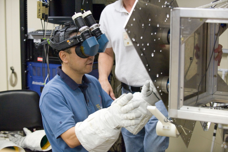 wearing virtual reality helmet and gloves, Furukawa trains on some of the tasks he would be working on aboard the ISS during Expedition 28/29