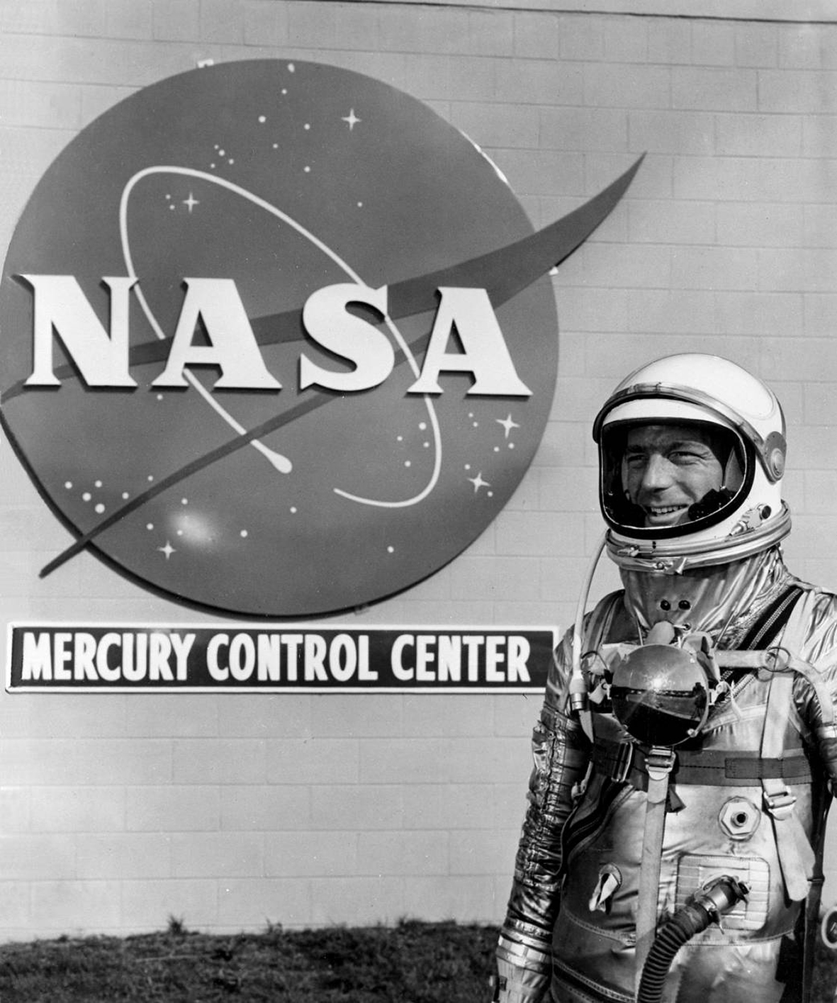 A fully-suited Carpenter poses outside NASA's Mercury Control Center at Cape Canaveral