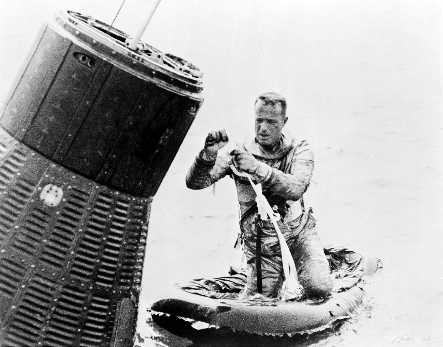 A wet-looking Carpenter kneels in his dinghy as he completes a water egress training exercise