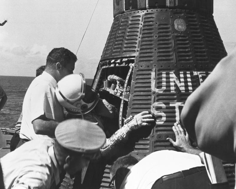 Schirra is helped out of the maerucyr spacecraft aboard the recovery ship at the end of his mission.